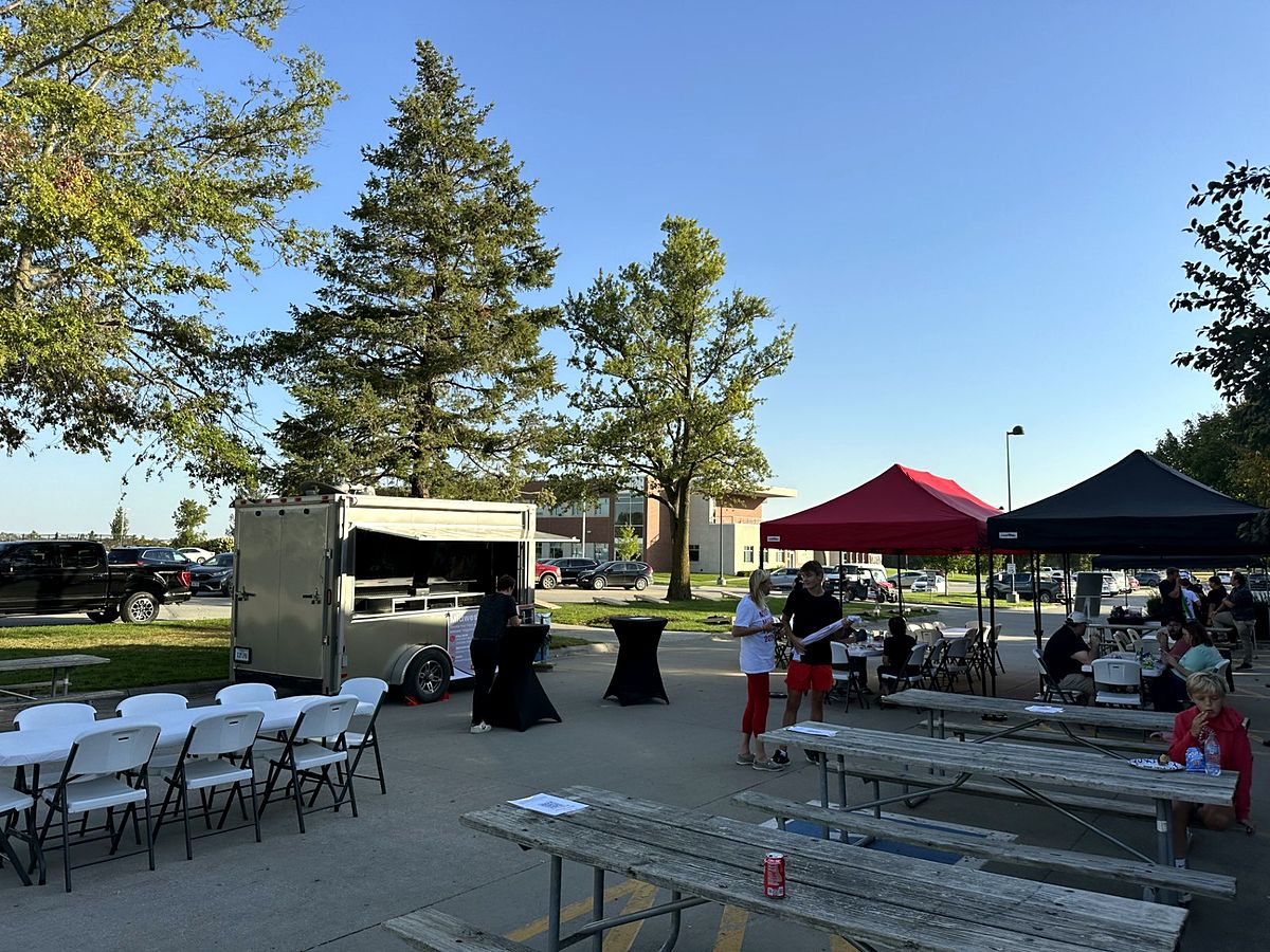 Corporate event setup with tables, tents and a trailer