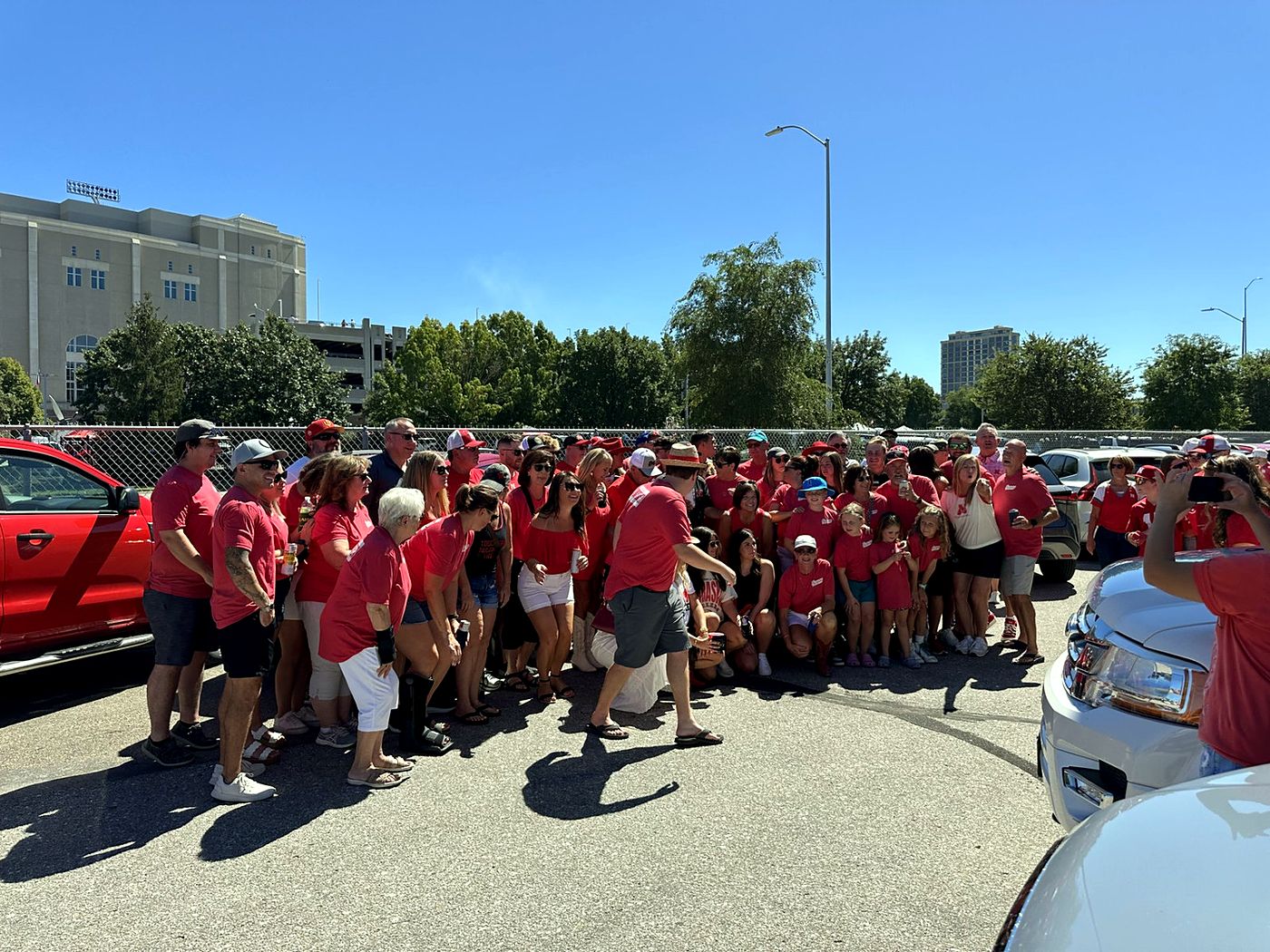 A large group of fans in red at a tailgate